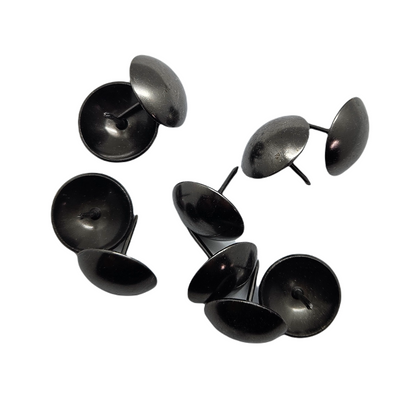 Black round upholstery tacks or furniture nails on white background.