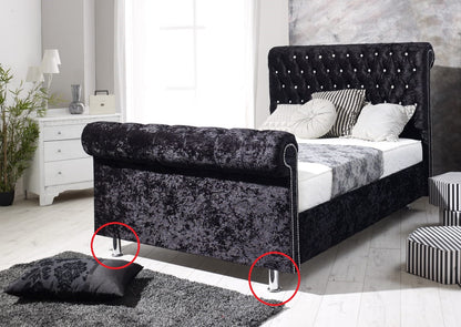 Chrome cylindrical feet/legs of the bed frame.